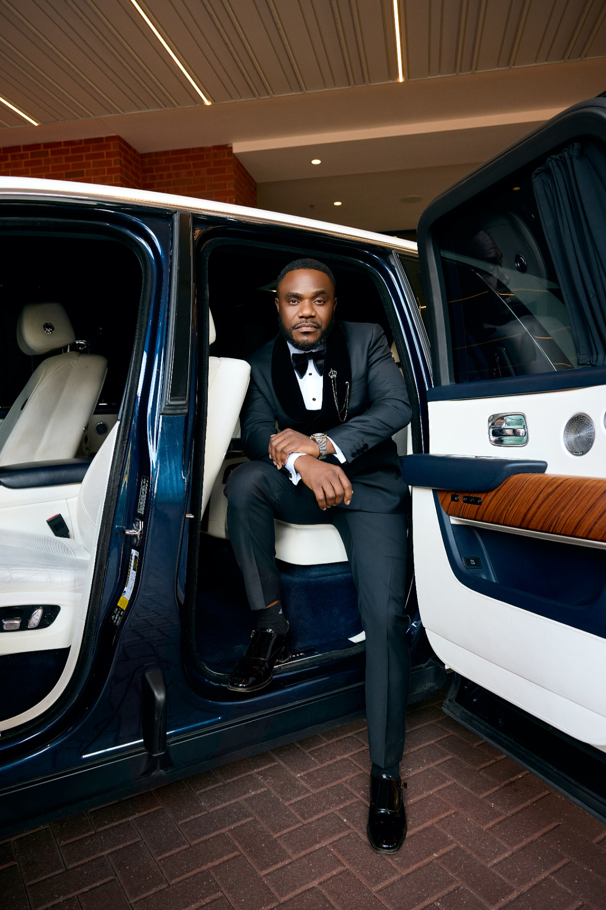 Arinze stepping out of the Rolls Royce in tuxedo