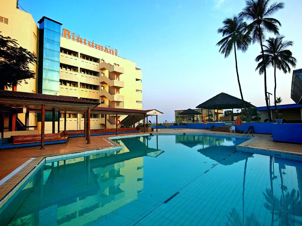Bintumani Hotel exterior with poolside palms